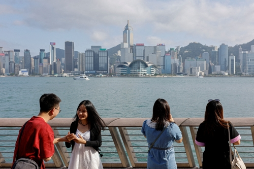 중국 본토 관광객들이 홍콩 침사추이에서 마천루 전경을 사진찍고 있다. 로이터 연합뉴스