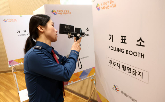 제22대 총선 사전투표일을 하루 앞둔 4일 오후 서울 종로구 사직동 주민센터에 마련된 사전투표 현장을 찾은 경찰관이 불법 카메라 설치 여부를 점검하고 있다. 2024.4.4  공동취재