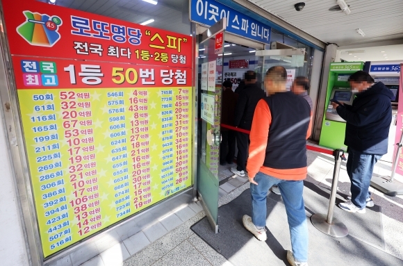 서울 한 복권판매점에서 고객들이 줄지어 복권 구입을 기다리고 있다. 뉴시스