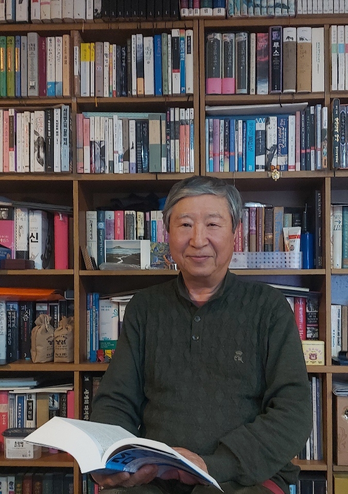 김석희 번역가가 자신의 서재에서 최근 개역판으로 낸 ‘모비 딕’을 펼쳐 들고 미소를 짓고 있다. 작가정신 제공