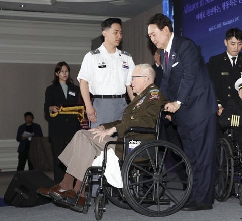 지난해 4월 25일(현지시간) 미국을 국빈 방문한 윤석열 대통령이 워싱턴DC의 한 호텔에서 열린 한국전 참전용사 행사에서 랠프 퍼켓 미 육군 예비역 대령에게 훈장을 수여한 뒤 그가 탄 휠체어를 밀어 주고 있다. 퍼켓 대령은 그로부터 약 1년이 지난 8일(현지시간) 97세를 일기로 세상을 떠났다. 워싱턴DC 연합뉴스