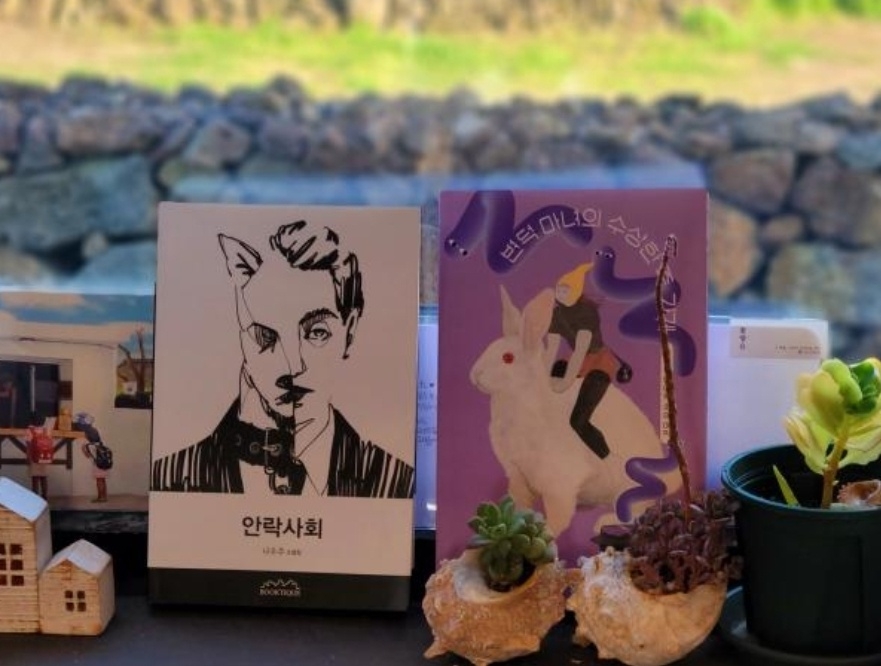 제주 소품카페‘꽃향유’에 전시된 나우주 작가의 책들.