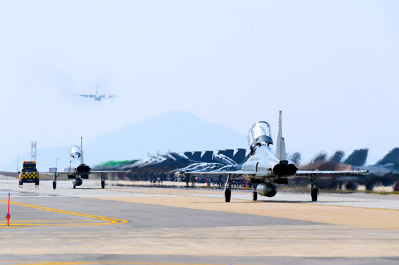 한미공군은 12일부터 오는 26일까지 최대규모의 연합공중훈련인 ‘2024년 연합편대군 종합훈련’을 공군 군산기지에서 실시한다고 밝혔다. 사진은 우리 공군의 F-5가 택싱하고 있는 가운데, 군산기지에 착륙하고 있는 우리 공군의 CN-235(상공). 2024.4.12  공군 제공