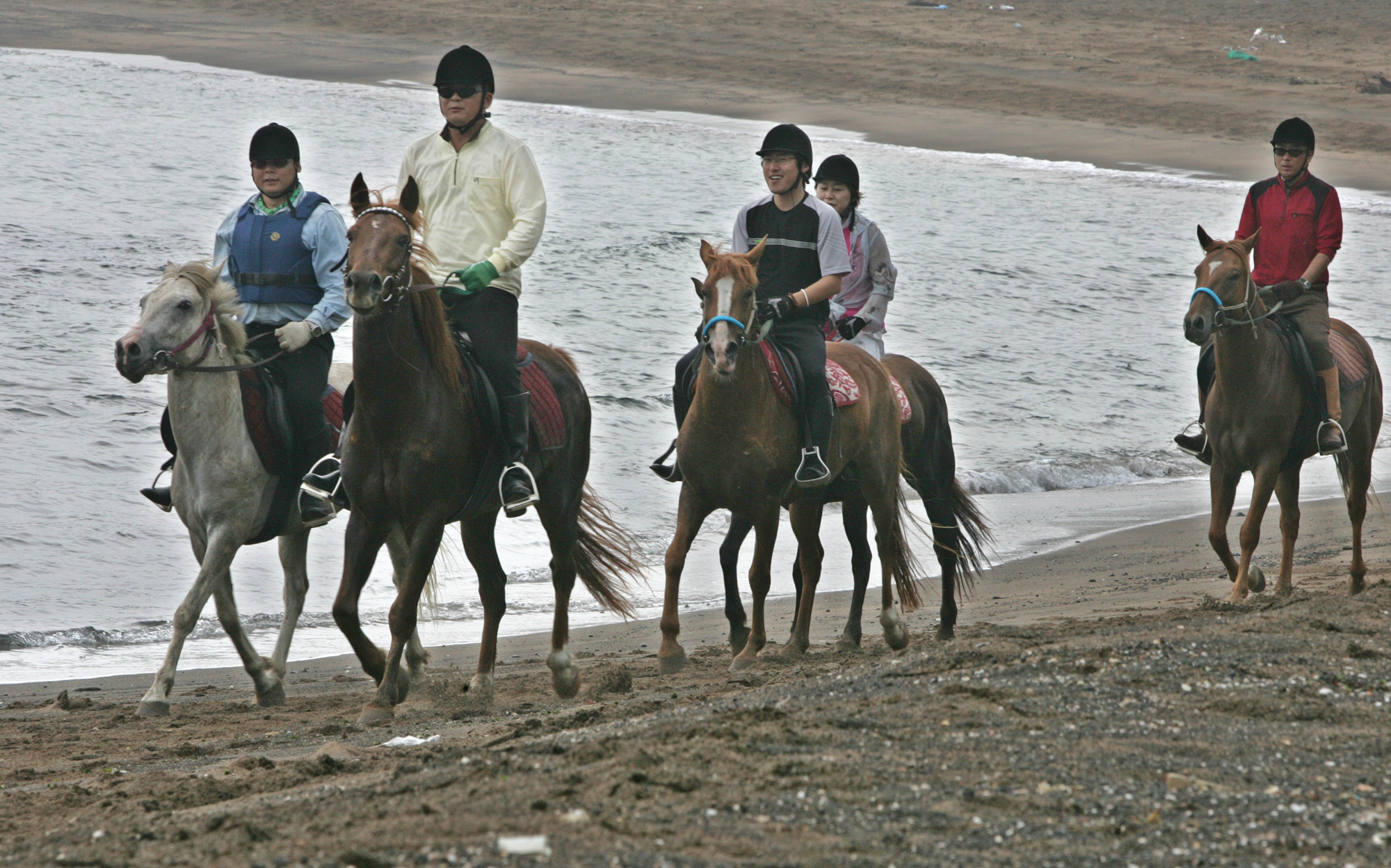 제주도 성산일출봉 인근 해안의 백사장에서 승마동우회 회원들이 말을 타는 모습. 연합뉴스