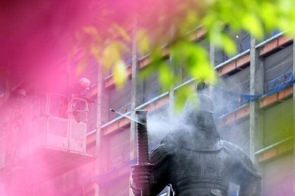 17일 오전 서울 광화문광장에서 서울시 관계자들이 이순신 장군 동상을 세척하고 있다. 2024.4.17 연합뉴스