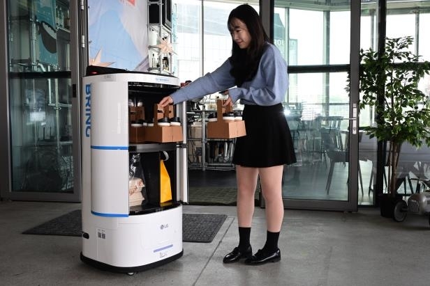 한 직원이 LG전자가 카카오모빌리티의 로봇 배송 서비스 ‘브링’에 공급한 ‘LG 클로이 서브봇’에 다량의 커피를 싣고 있다. LG전자 제공