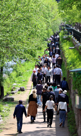 23일 점심시간에 서울 종로구 광통교 인근 청계천을 찾은 직장인들이 산책을 즐기고 있다. 2024.4.23 연합뉴스