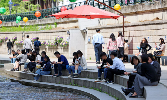 23일 점심시간에 서울 청계천을 찾은 직장인 및 시민들이 준비해온 도시락을 먹으며 휴식을 즐기고 있다. 2024.4.23 연합뉴스