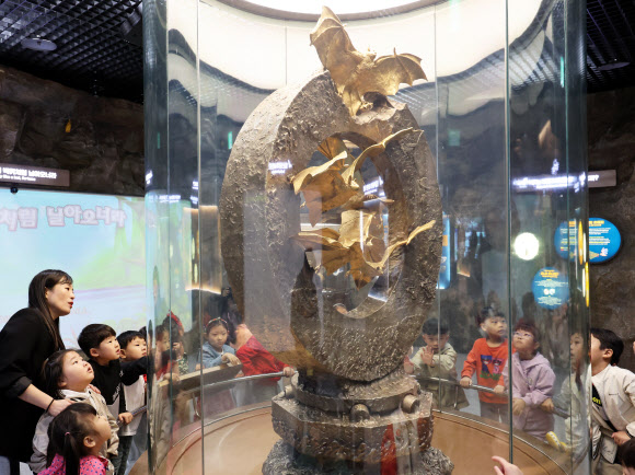 24일 전남 함평군 함평엑스포공원을 찾은 한 유치원 아이들이 순금으로 만든 황금박쥐상을 바라보고 있다.  2008년 30억원을 들여 순금 162kg을 넣어 제작한 함평 황금박쥐상은 지난 3월 어두컴컴한 동굴전시장을 떠나 공원 내 문화유물전시관으로 옮겨왔다. 현재 150억원가량의 가치를 지닌 것으로 추정된다. 2024.4.24 연합뉴스