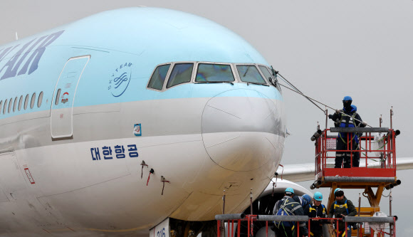 25일 인천국제공항 대한항공 항공기 정비고에서 관계자들이 777-300ER 항공기 동체를 세척하고 있다. 2024.4.25  연합뉴스