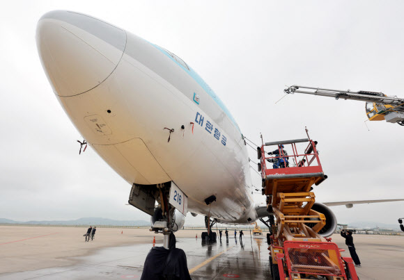 25일 인천국제공항 대한항공 항공기 정비고에서 관계자들이 777-300ER 항공기 동체를 세척하고 있다. 2024.4.25  연합뉴스