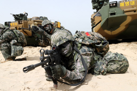 25일 경북 포항 한 해안에서 해병대원들이 장갑차를 타고 해안에 상륙한 뒤 총을 들고 주변을 경계하고 있다. 해병대와 해군, 육군, 공군 등은 지난 17일부터 한국형 상륙돌격장갑차(KAAV)와 대형수송함(LPH), 상륙함, 헬기, 수송기 등을 동원해 대규모 합동상륙훈련을 하고 있다. 2024.4.25  연합뉴스