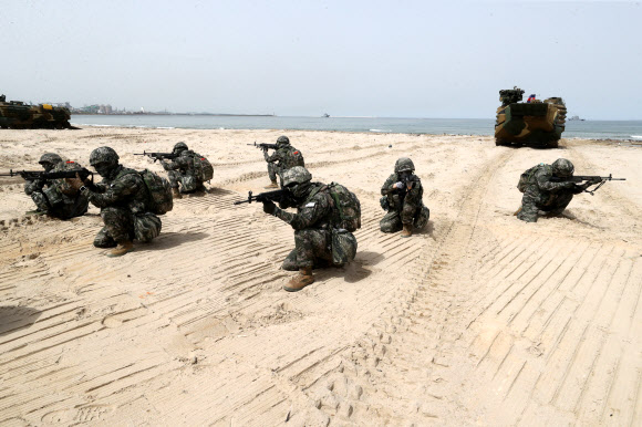 25일 경북 포항 한 해안에서 해병대원들이 장갑차를 타고 해안에 상륙한 뒤 총을 들고 주변을 경계하고 있다. 해병대와 해군, 육군, 공군 등은 지난 17일부터 한국형 상륙돌격장갑차(KAAV)와 대형수송함(LPH), 상륙함, 헬기, 수송기 등을 동원해 대규모 합동상륙훈련을 하고 있다. 2024.4.25  연합뉴스