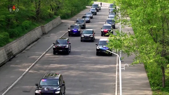 김정은 북한 국무위원장이 지난 25일 조선인민혁명군 창건 92주년을 맞아 김일성군사종합대학을 축하 방문했다고 조선중앙TV가 26일 보도했다. 김 위원장이 탄 아우루스 차량(가운데)이 신형 토요타 랜드크루저로 보이는 경호차량의 호위를 받으며 대학으로 향하고 있다.  2024.4.26  조선중앙TV 화면·연합뉴스