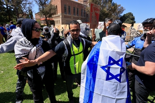 28일(현지시간) 미국 캘리포니아주 로스앤젤레스의 캘리포니아대 로스앤젤레스(UCLA) 캠퍼스에서 팔레스타인 지지 시위대(왼쪽)와 친이스라엘 시위대가 대치하고 있다.  로이터 연합뉴스