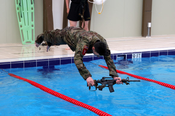 30일 경기도 동두천시 캠프 케이시에서 열린 미2사단/한미연합사단 최고 분대 선발대회 수중 생존 테스트에서 미군 장병이 총기를 든 채 물로 뛰어들고 있다. 2024.4.30 연합뉴스