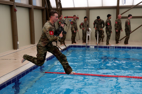 30일 경기도 동두천시 캠프 케이시에서 열린 미2사단/한미연합사단 최고 분대 선발대회 수중 생존 테스트에서 미군 장병이 총기를 든 채 물로 뛰어들고 있다. 2024.4.30 연합뉴스