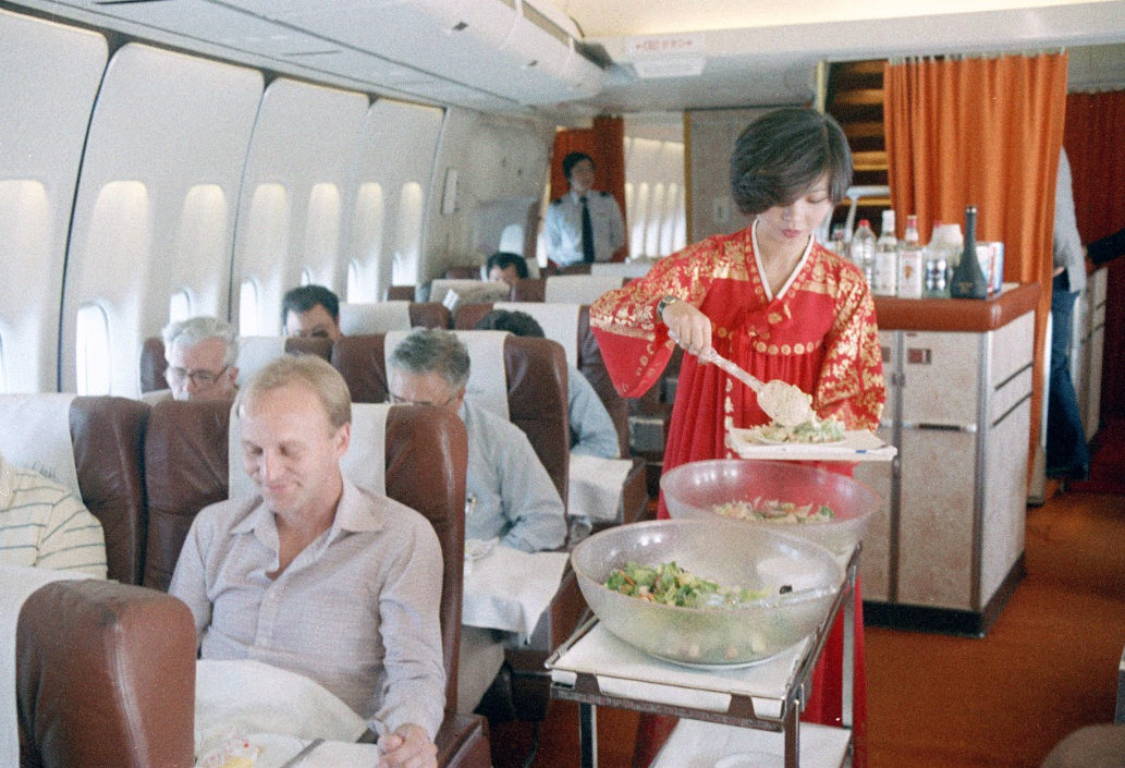 1980년대 기내서비스 모습. 승무원이 한복을 입고 승객 눈 앞에서 즉석해서 메뉴를  담아 제공하는 모습이 이채롭다. 대한항공 제공