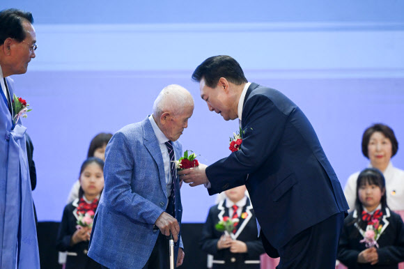 어르신에게 카네이션 달아드리는 윤석열 대통령