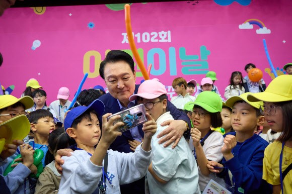 윤석열 대통령이 5일 청와대 연무관에서 열린 어린이날 초청 행사에 참석해 어린이들과 셀카를 찍고 있다. 2024.5.5  대통령실 제공