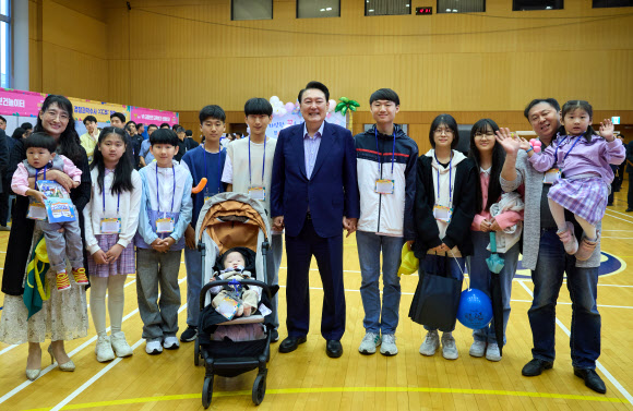 윤석열 대통령이 5일 청와대 연무관에서 열린 어린이날 초청 행사에 참석해 10남매를 키우는 박성용, 이계정 씨 가족과 기념촬영을 하고 있다. 2024.5.5  대통령실 제공