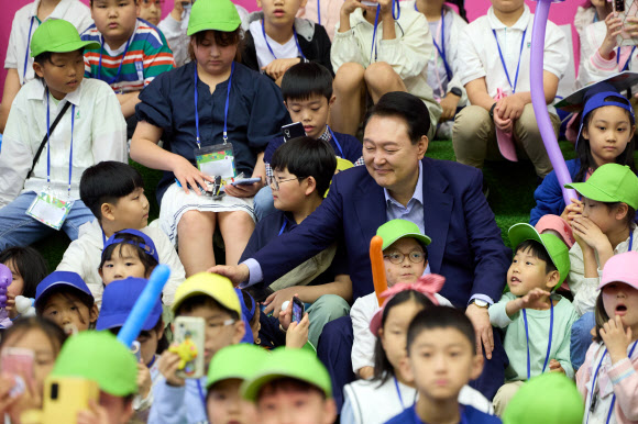 윤석열 대통령이 5일 청와대 연무관에서 열린 어린이날 초청 행사에 참석해 ‘버블 매직쇼’ 공연을 관람하는 어린이들과 대화하고 있다. 2024.5.5  대통령실 제공
