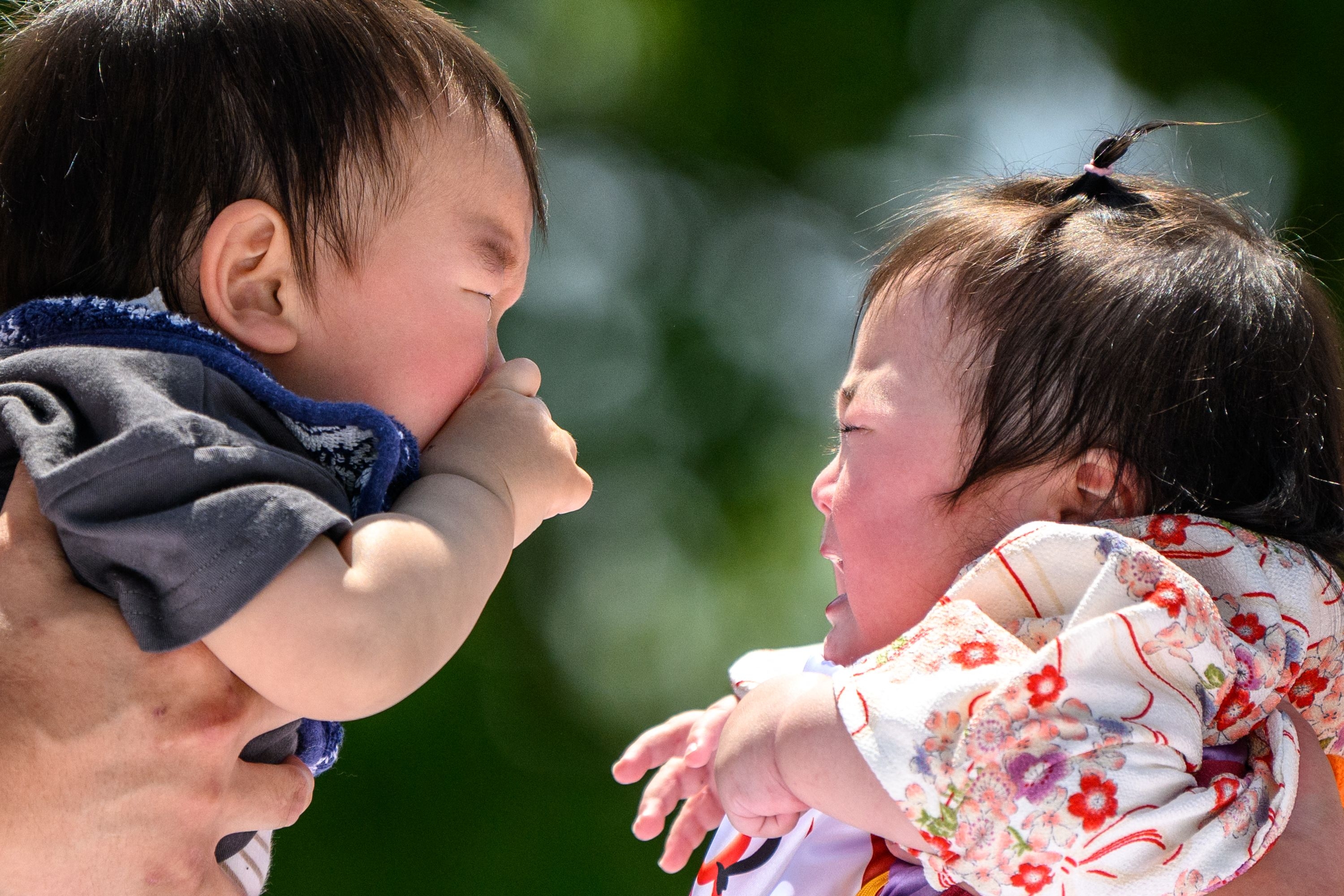 스모 선수들이 지난 4월 28일 도쿄 센소지 절에서 열린 ‘우는 아기 스모’ 경기에서 아이들을 안고 있다. AFP 연합뉴스