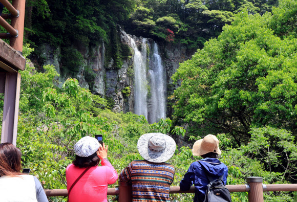 6일 제주 서귀포시 엉또폭포를 찾은 관광객과 나들이객들이 시원하게 떨어지는 물줄기를 감상하고 있다. 엉또폭포는 평소에 물이 떨어지지 않다가 한라산에 폭우가 내렸을 때만 시원한 물줄기를 볼 수 있다. 한라산 고지대에는 지난 4∼5일 최대 900㎜가 넘는 폭우가 쏟아졌다. 2024.5.6 연합뉴스