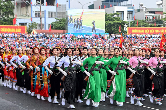 Vietnamese women in traditional dress carrying assault weapons parade during official celebrations of the 70th anniversary of the 1954 Dien Bien Phu victory over French colonial forces at a stadium in Dien Bien Phu city on May 7, 2024. War veterans, soldiers and dignitaries gathered in Vietnam‘s Dien Bien Phu on May 7 to mark the 70th anniversary of the battle that ultimately brought an end to the French empire in Indochina. AFP 연합뉴스
