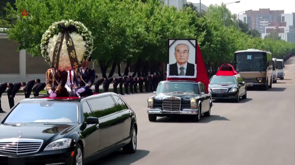북한 고 김기남 전 노동당 선전 담당 비서의 장의식이 지난 9일 평양에서 국장으로 진행됐다고 조선중앙TV가 10일 보도했다. 행렬 선두에 김정은 명의의 화환이 실린 마이바흐 차량이, 뒤이어 메르세데스 벤츠-600 차량에는 김기남 초상화를, 세 번째 마이바흐 차량에는 운구를 싣고 신미리애국열사릉으로 이동하고 있다. 2024.5.10  조선중앙TV 화면·연합뉴스