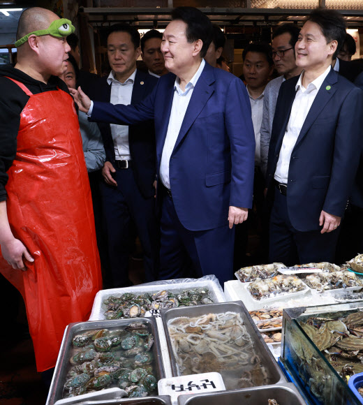 윤석열 대통령이 10일 오후 서울 서대문구 영천시장을 찾아 수산 매장에서 상인과 대화하고 있다. 윤 대통령 오른쪽은 김주현 대통령실 민정수석비서관. 2024.5.10 연합뉴스