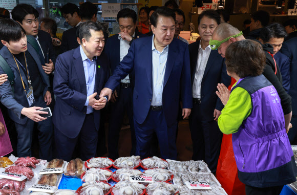 윤석열 대통령이 10일 오후 서울 서대문구 영천시장을 찾아 수산 매장에서 박춘섭 대통령실 경제수석비서관을 상인에게 소개하고 있다. 2024.5.10 연합뉴스