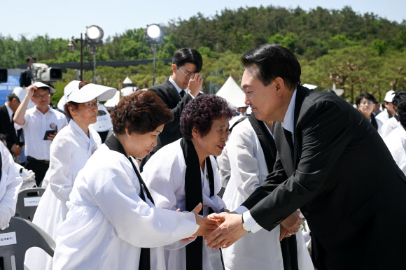 윤석열 대통령이 18일 광주시 북구 국립5·18민주묘지에서 열린 제44주년 5·18민주화운동 기념식이 끝난 뒤 오월어머니 회원들과 인사하고 있다.   2024.5.18. 대통령실 제공