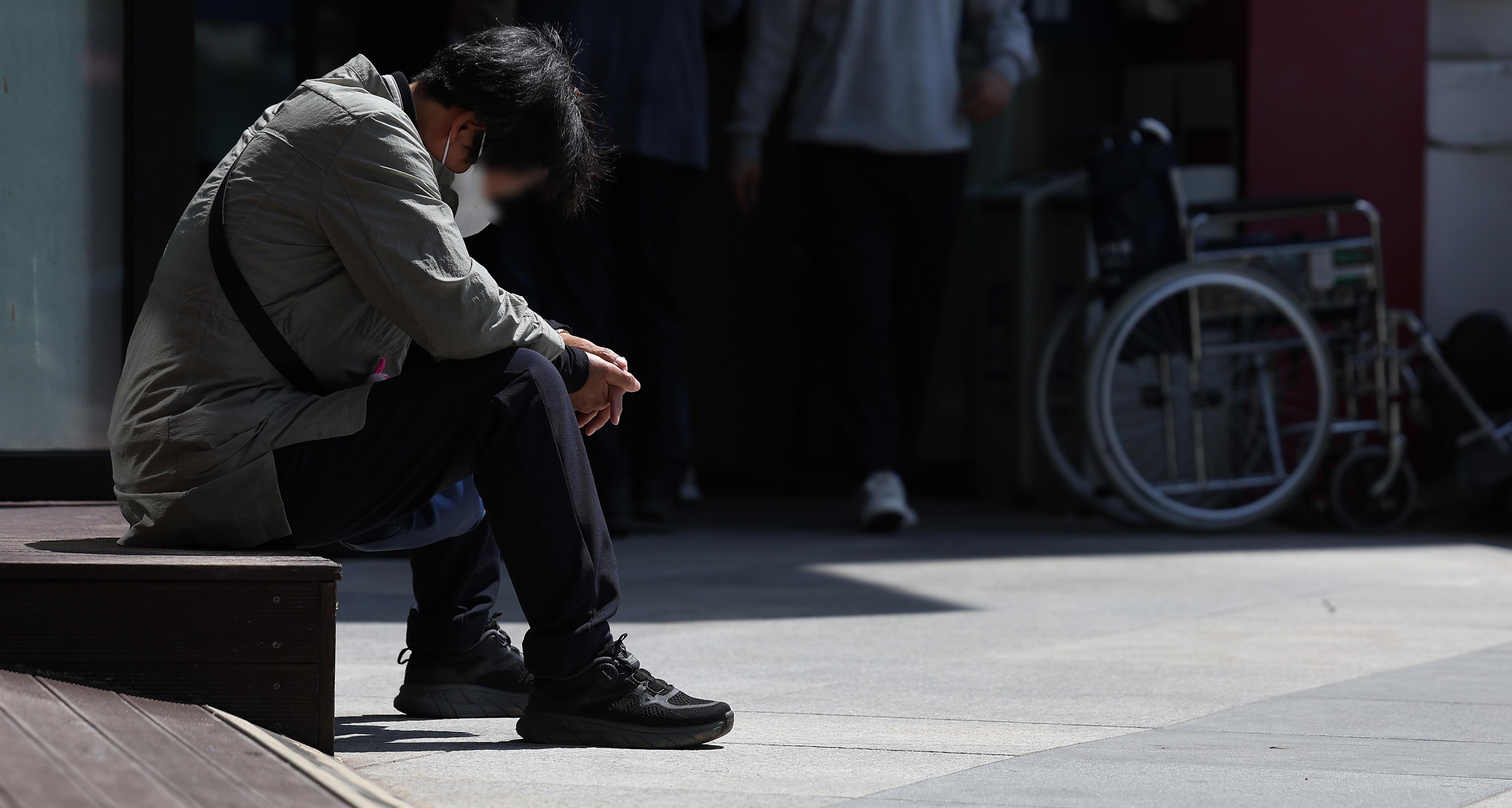 전공의들이 의대 증원에 반발해 환자 곁을 떠난 지 19일로 석 달째에 접어든 가운데 서울 시내 한 대형병원 계단에 앉아 있는 환자의 모습이 힘겨워 보인다. 뉴스1