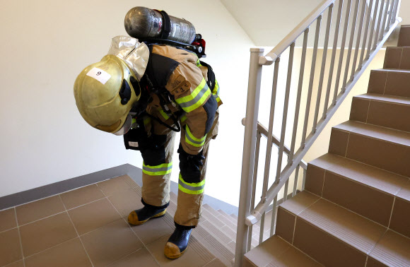 21일 오전 인천 부평구 한 고층 아파트에서 열린 부평소방서 소방관 고층 아파트 계단 오르기 대회에 참가자가 공기호흡기를 착용한 채 계단을 오르며 힘들어하고 있다. 이번 대회는 고층 건물 재난사고 대비 신속한 현장 대응과 소방관 체력 증진을 위해 진행됐다. 2024.5.21  연합뉴스