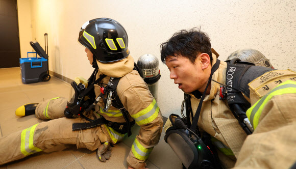 21일 오전 인천 부평구 한 고층 아파트에서 열린 부평소방서 소방관 고층 아파트 계단 오르기 대회에 참가자들이 공기호흡기를 착용한 채 40층 계단을 오른 뒤 힘들어하고 있다. 이번 대회는 고층 건물 재난사고 대비 신속한 현장 대응과 소방관 체력 증진을 위해 진행됐다. 2024.5.21  연합뉴스