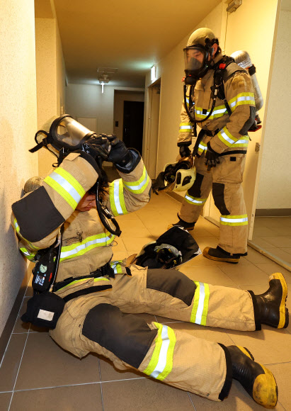 21일 오전 인천 부평구 한 고층 아파트에서 열린 부평소방서 소방관 고층 아파트 계단 오르기 대회에 참가자들이 40층 계단을 오른 뒤 공기호흡기를 벗고 있다. 이번 대회는 고층 건물 재난사고 대비 신속한 현장 대응과 소방관 체력 증진을 위해 진행됐다. 2024.5.21  연합뉴스