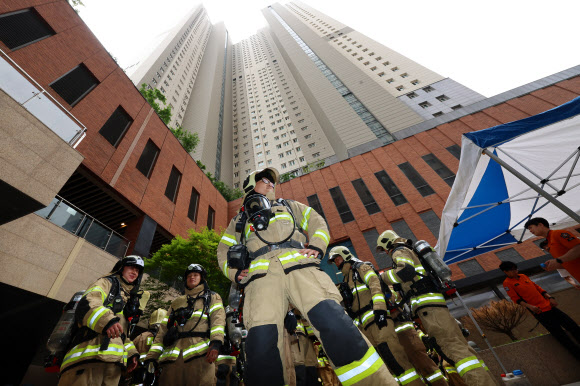 21일 오전 인천 부평구 한 고층 아파트에서 열린 부평소방서 소방관 고층 아파트 계단 오르기 대회에 참가자들이 출발 전 준비운동을 하고 있다. 이번 대회는 고층 건물 재난사고 대비 신속한 현장 대응과 소방관 체력 증진을 위해 진행됐다. 2024.5.21  연합뉴스
