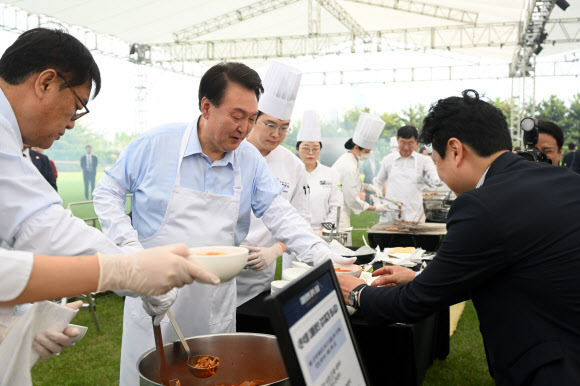 윤석열 대통령이 24일 서울 용산 대통령실 청사 잔디마당에서 열린 ‘대통령의 저녁 초대’  출입기자단 초청 만찬 간담회에서 김치찌개를 배식하고 있다. 2024.5.24  대통령실 제공