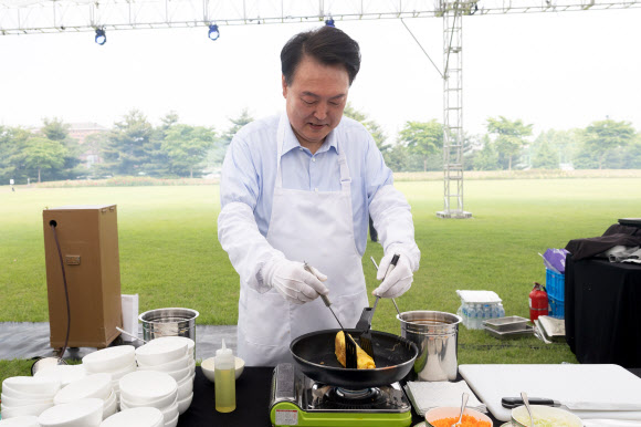윤석열 대통령이 24일 서울 용산 대통령실 청사 잔디마당에서 열린 ‘대통령의 저녁 초대’  출입기자단 초청 만찬 간담회에서 계란말이를 만들고 있다. 2024.5.24  대통령실 제공