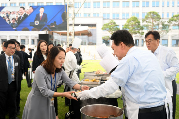 윤석열 대통령이 24일 서울 용산 대통령실 청사 잔디마당에서 열린 ‘대통령의 저녁 초대’ 출입기자단 초청 만찬 간담회에서 취재진에게 김치찌개를 배식하고 있다. 2024.5.24  대통령실 제공