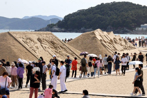 맑은 초여름 날씨를 보인 25일 오후 부산 해운대구 해운대해수욕장을 찾은 시민들이 모래 작품들을 감상하고 있다. 해운대 모래축제는 24일부터 27일까지 해운대해수욕장에서 ‘세계 미술관 여행’을 주제로 열린다. 2024.5.25  연합뉴스