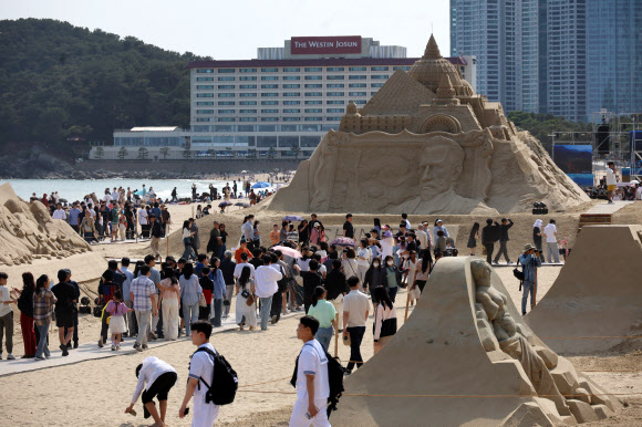맑은 초여름 날씨를 보인 25일 오후 부산 해운대구 해운대해수욕장을 찾은 시민들이 모래 작품들을 감상하고 있다. 해운대 모래축제는 24일부터 27일까지 해운대해수욕장에서 ‘세계 미술관 여행’을 주제로 열린다. 2024.5.25  연합뉴스
