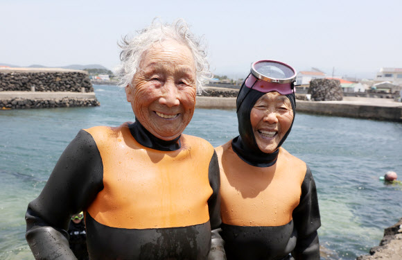 25일 오후 제주시 한림읍 귀덕2리 포구에서 92살 김유생(왼쪽) 해녀와 91살 강두교 해녀가 은퇴식에 앞서 마지막 물질을 마치고 나서 환하게 웃고 있다. 2024.5.25  연합뉴스