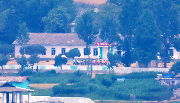 정부의 9·19 군사합의 효력정지 결정으로 대북 확성기 방송 재개는 물론 군사분계선 일대의 군사 훈련이 가능해진 가운데 7일 경기도 파주시 오두산통일전망대에서 바라본 북한 황해북도 개풍군 임한소학교에서 학생들이 운동장을 뛰고 있다. 2024.6.7  연합뉴스