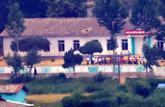 정부의 9·19 군사합의 효력정지 결정으로 대북 확성기 방송 재개는 물론 군사분계선 일대의 군사 훈련이 가능해진 가운데 7일 경기도 파주시 오두산통일전망대에서 바라본 북한 황해북도 개풍군 임한소학교에서 학생들이 운동장을 뛰고 있다. 2024.6.7  연합뉴스