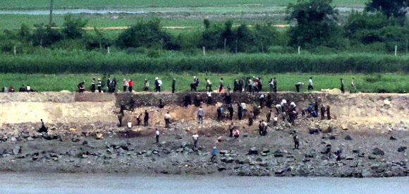10일 오후 인천 강화군 강화평화전망대에서 바라본 북한 황해도 개풍군 마을에서 북한 주민들이 제방 보수작업을 하고 있다. 2024.6.10. 연합뉴스
