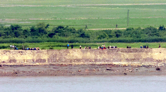10일 오후 인천 강화군 강화평화전망대에서 바라본 북한 황해도 개풍군 마을에서 북한 주민들이 제방 보수작업을 하다 점심을 먹고 있다. 2024.6.10. 연합뉴스