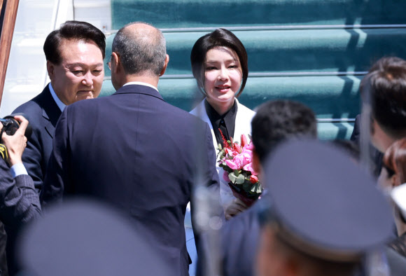 우즈베키스탄을 국빈 방문한 윤석열 대통령과 김건희 여사가 13일(현지시간) 우즈베키스탄 타슈켄트 국제공항에 도착해 전용기인 공군 1호기에서 내려 꽃다발을 받고 있다. 2024.6.13  연합뉴스