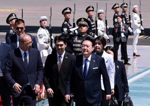 우즈베키스탄을 국빈 방문한 윤석열 대통령과 김건희 여사가 13일(현지시간) 우즈베키스탄 타슈켄트 국제공항에 도착해 아리포프 우즈베키스탄 총리의 안내를 받으며 의장대를 지나 공항을 빠져나가고 있다. 2024.6.13  연합뉴스
